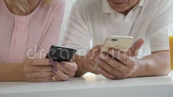 退休的高加索夫妇在家学习使用智能手机视频的预览图