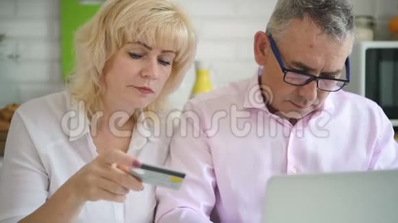 退休夫妇在舒适的厨房里买网上购物视频的预览图