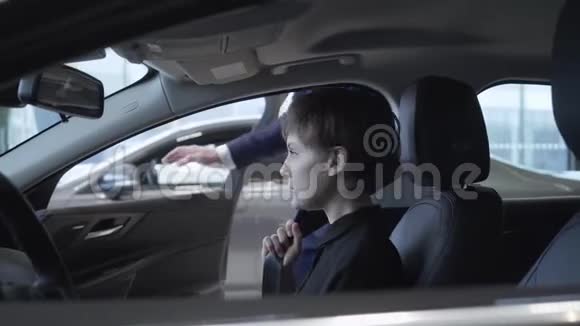 一位留着短发的漂亮女孩坐在新车的乘客车厢里检查新车视频的预览图