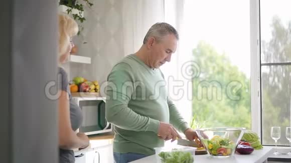 女性养老金领取者帮助成熟的丈夫准备沙拉视频的预览图