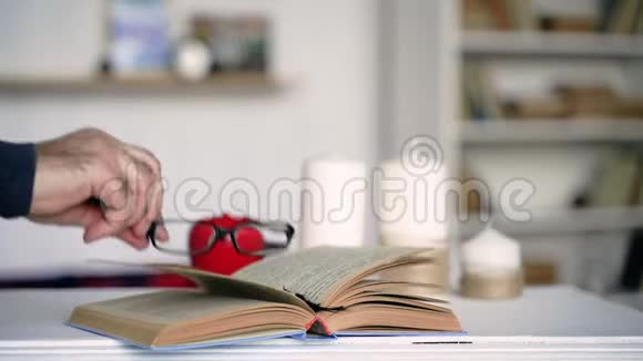 书桌旁的书上的眼镜视频的预览图