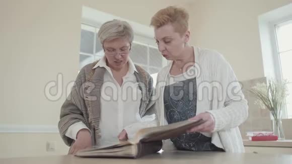 两个成年女友的肖像考虑一张相册一位白发苍苍戴眼镜女朋友的老年妇女视频的预览图