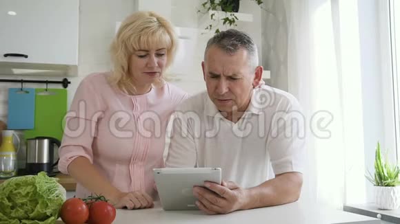 白人退休夫妇用平板电脑做网上购物视频的预览图