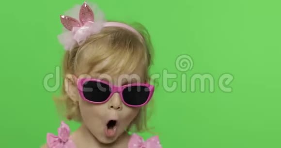 积极的女孩有感情地唱着粉红色泳衣的相机铬键视频的预览图