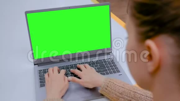 女人在咖啡馆里用空白的绿色屏幕打字视频的预览图