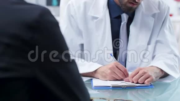 近距离拍摄医生手在剪贴板上做笔记视频的预览图