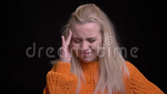 一位年轻迷人的白种人女性的特写镜头长着金色长发在镜头前头痛视频的预览图
