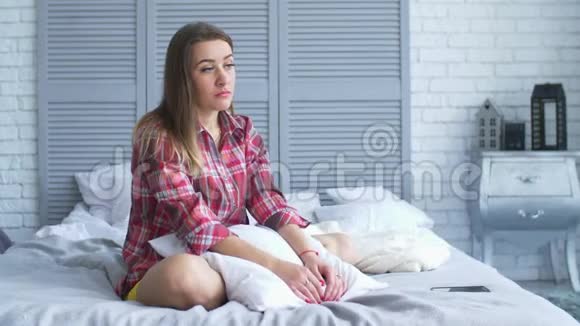 伤心绝望的女人抱着枕头坐在床上视频的预览图