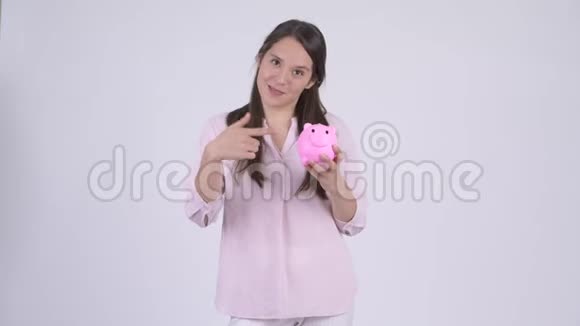 年轻快乐的多民族女商人拿着储蓄罐竖起大拇指视频的预览图
