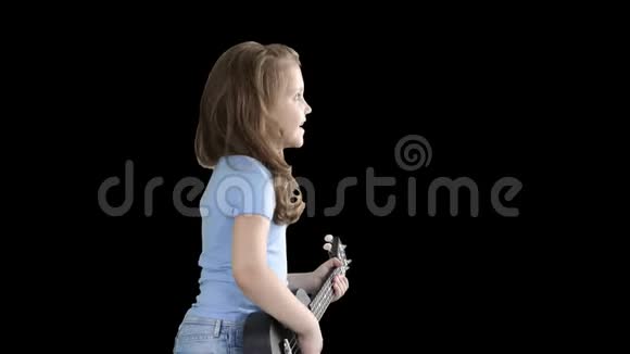 可爱的小女孩在Alpha频道的四弦琴上边走边唱视频的预览图
