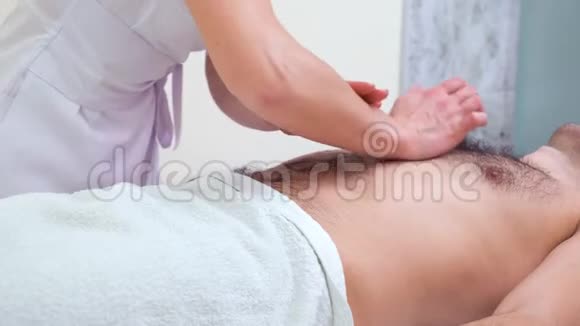 女性双手在温泉沙龙为男性顾客做腹部放松按摩视频的预览图
