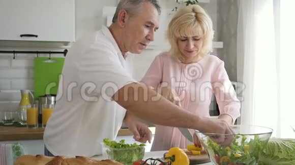 老一辈夫妇一起在厨房做午餐沙拉视频的预览图