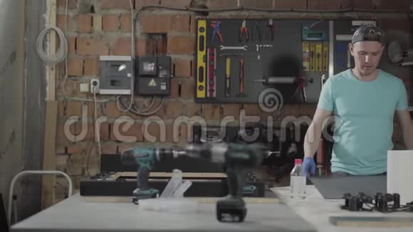 在车库里用工具工作的专业工匠手工制造的概念工匠在车间工作视频的预览图
