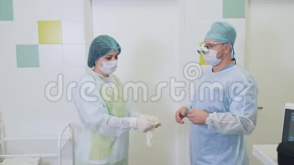护士帮助外科医生在医院进行硬化手术前戴上无菌手套视频的预览图