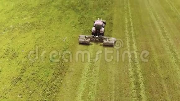 农民在一辆红色拖拉机和一台联合安装的割草机与圆盘旋转刀割草成青贮饲料牲畜视频的预览图