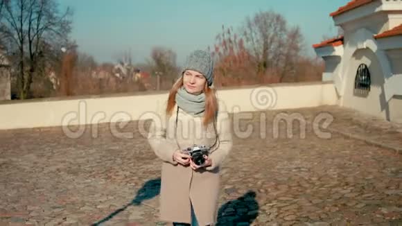 年轻的旅游女士走在中世纪城堡附近用相机拍照视频的预览图