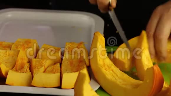 一个人把一个橙色的南瓜切成碎片放在托盘上世界素食日视频的预览图