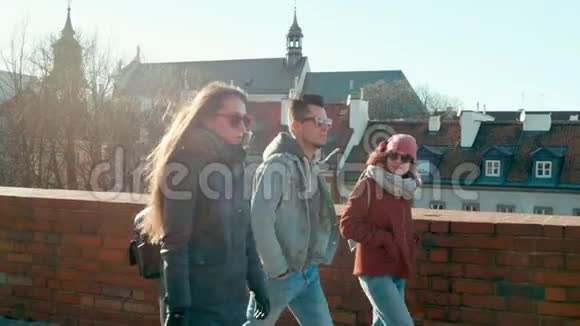 戴太阳镜的千禧一代三个年轻的成年朋友在城里散步视频的预览图