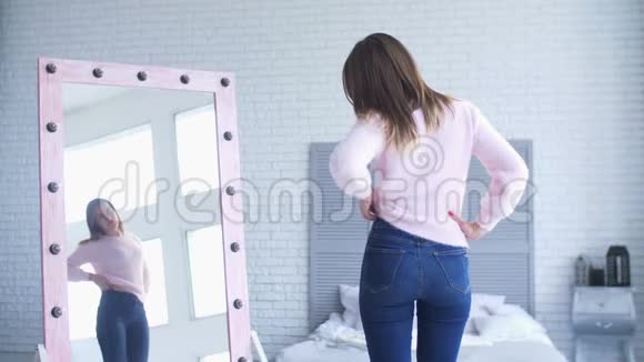 不高兴的女人在家里检查她身体上的脂肪视频的预览图