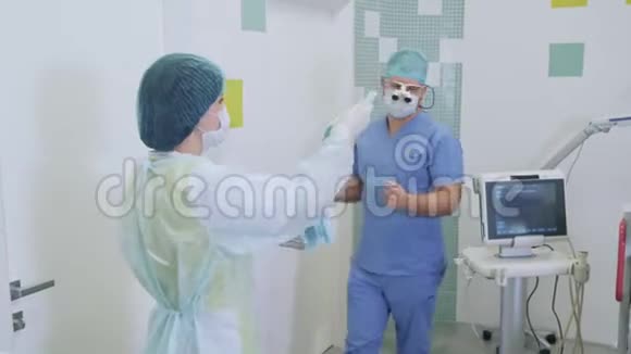 护士在手术前帮助医生在手术室穿无菌衣服视频的预览图