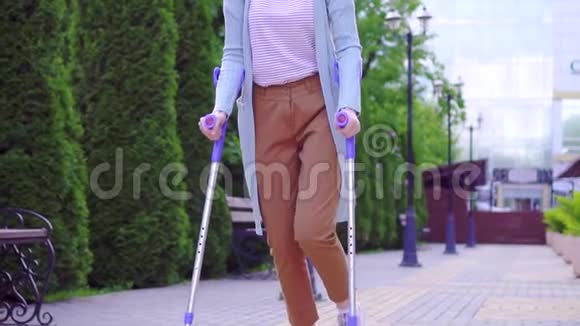 美丽时尚积极向上的年轻女性拄着拐杖走在阳光明媚的街道上视频的预览图