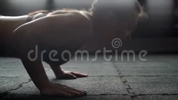 在健身房里做俯卧撑的运动女性在缓慢的运动中将脸贴近视频的预览图