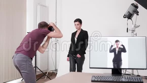 模特正在为摄影师摆姿势照片显示在电脑屏幕上视频的预览图
