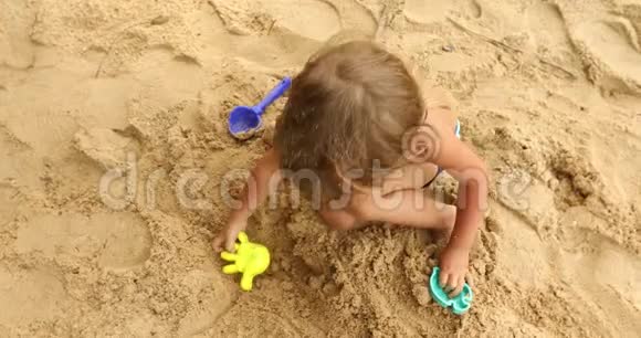 在海滩上玩沙子的庄稼汉视频的预览图