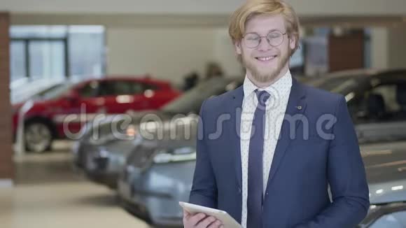 一位戴着商务套装戴着眼镜站在现代汽车大厅的成功留胡子卖家的肖像视频的预览图