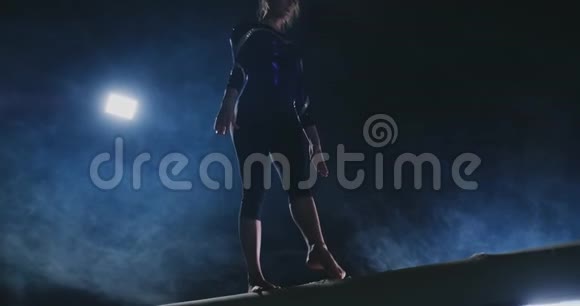 女子职业体操运动员在平衡木上做跳跃动作动作缓慢视频的预览图