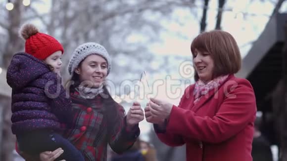 一家三代微笑的女人享受在一起的时光捧着闪闪发光家庭观念妈妈天视频的预览图