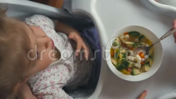 一个女人用汤匙喂一个小女孩视频的预览图