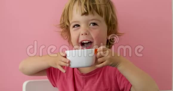 快乐的孩子从杯子里喝牛奶视频的预览图