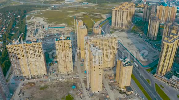 高空俯视飞行大规模建造住宅综合体以看到建筑起重机和沥青高W视频的预览图