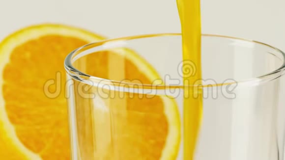 将橙色软饮料倒入玻璃中特写慢动作拍摄红色视频的预览图
