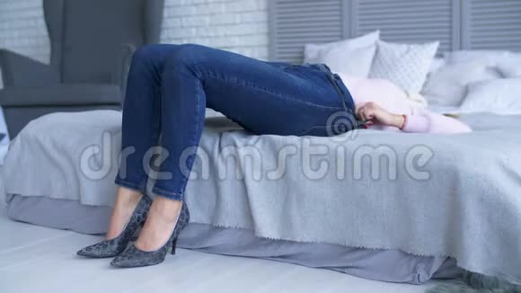 在床上挣扎着关上牛仔裤的漂亮女人视频的预览图