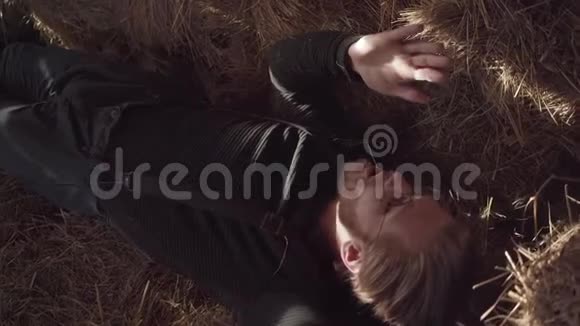 一个长胡子的家伙戴着眼镜辛勤工作后躺在谷仓的干草上一个农场工人正在休息视频的预览图