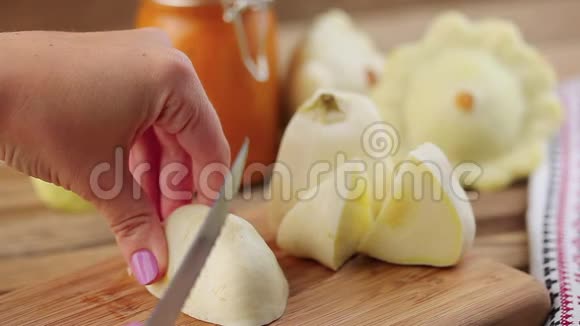 女性用刀子在木切割板上切割白色的小南瓜视频的预览图