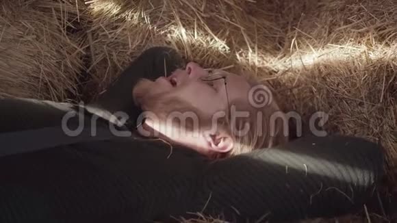 戴眼镜的留胡子的人的画像嘴里放着一根稻草躺在干草里年轻体贴的农民视频的预览图