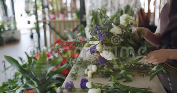销售妇女在花店布置花卉的缓慢动作创造构图视频的预览图