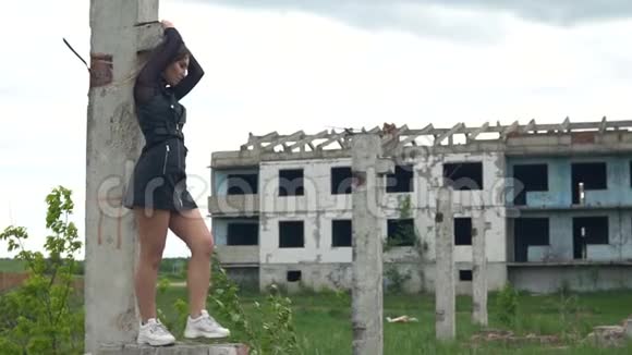 一栋废弃建筑背景上的女孩头发在风中飘扬慢动作视频的预览图