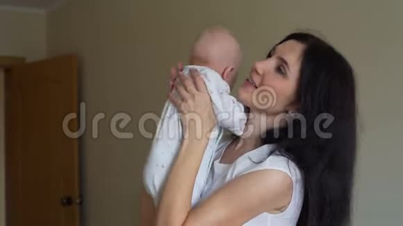 年轻的母亲温柔地抱着她的孩子视频的预览图