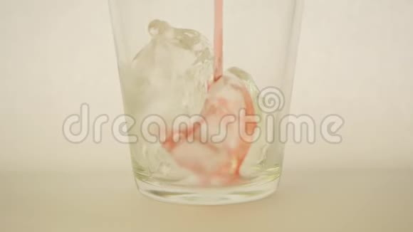 将樱桃汁倒入装有冰块的玻璃杯中视频的预览图