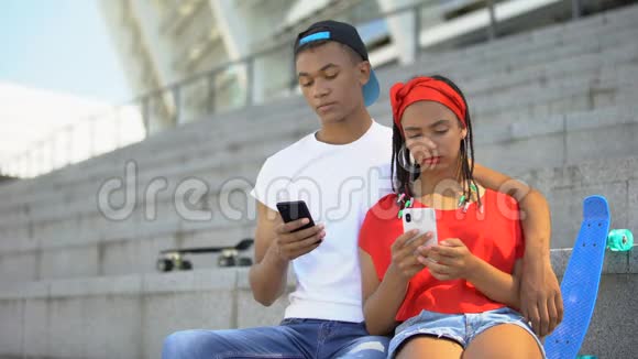 青少年夫妇一起在智能手机上滚动社交网络视频的预览图