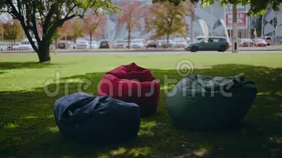 城市环境中草地上的五彩软扶手椅视频的预览图