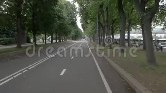 在阴天摄像机沿着城市公园的自行车道移动视频的预览图