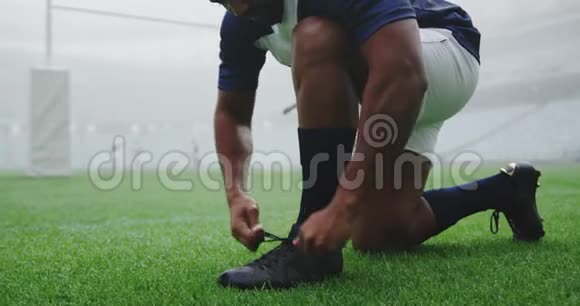 橄榄球运动员在体育场系鞋带4k视频的预览图