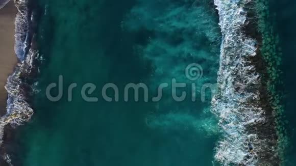 靠近海岸的大西洋表面的俯视图波浪卷过防波堤到达海岸视频的预览图
