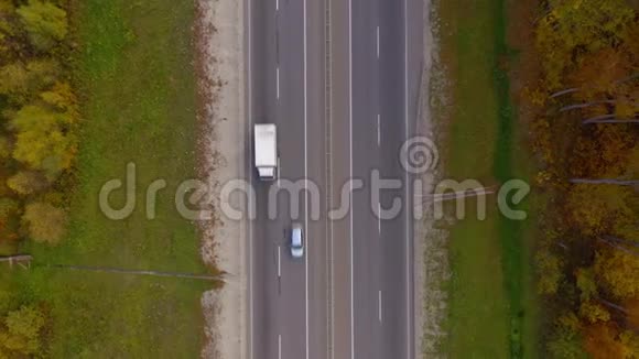 秋季森林环绕的道路上的交通俯视图视频的预览图