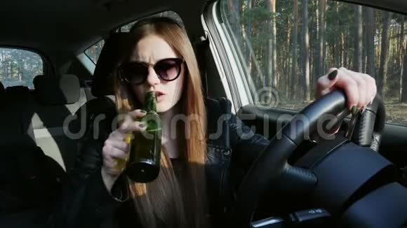 醉酒的女司机在车里喝啤酒在方向盘上睡着了视频的预览图